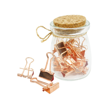 Binder clips in glass jar with cork lip